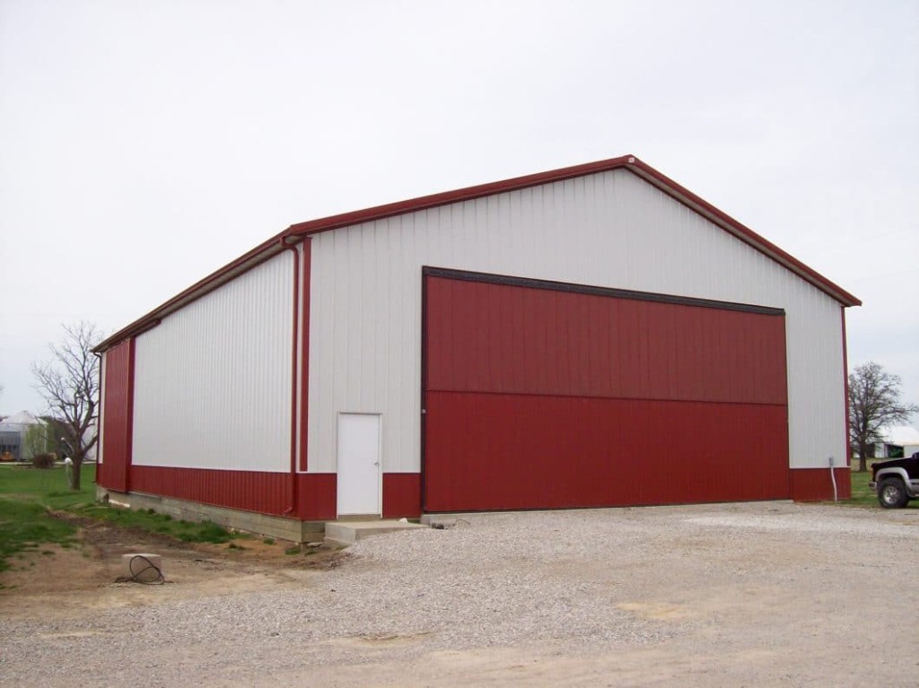 Post-frame building with a large bi-fold door for wide equipment access.