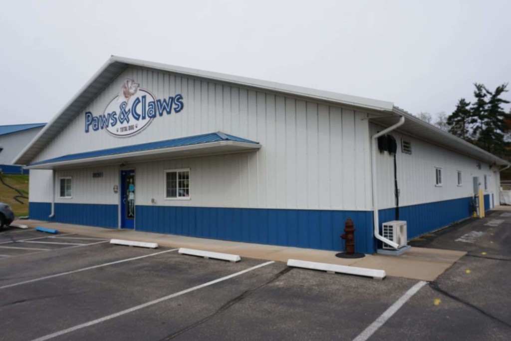 Post-frame commercial building with an eyebrow overhang above the front entrance.