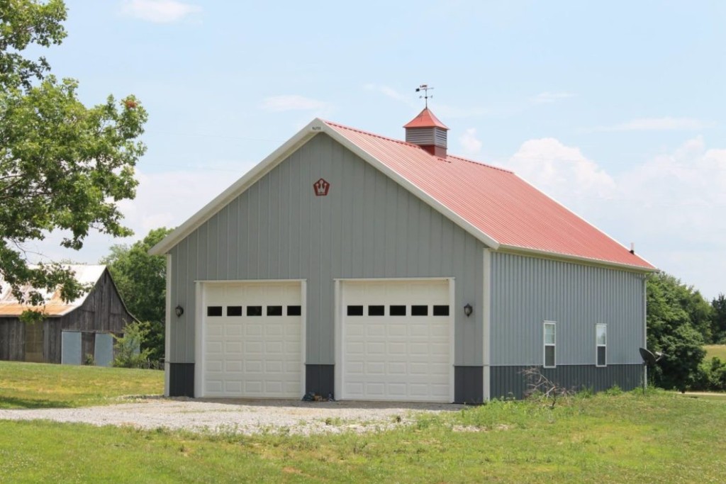 Post-frame garage with multiple overhead doors for vehicle and equipment access.
