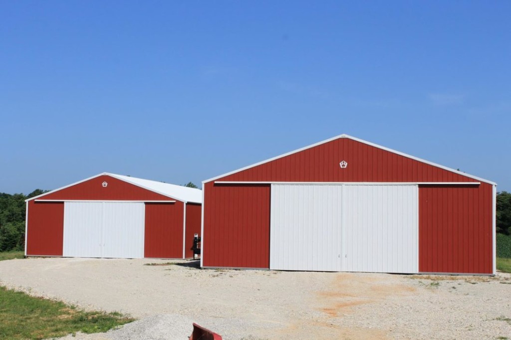 Post-frame pole barn with dual sliding doors for wide equipment access.