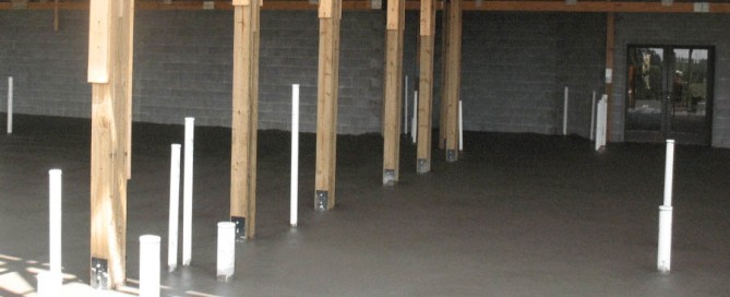 Pole barn foundation design with concrete pad and interior support posts.