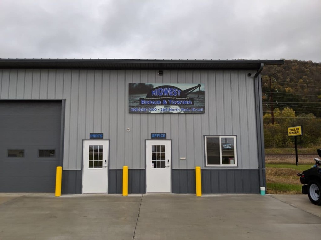 Post-frame commercial building with steel walk doors next to overhead door bays.