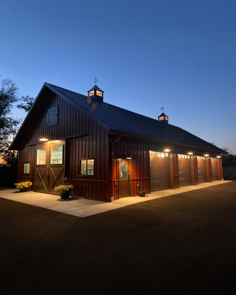 Machinery Storage Building at Dusk Custom machinery storage building illuminated at dusk with red steel siding and cupolas