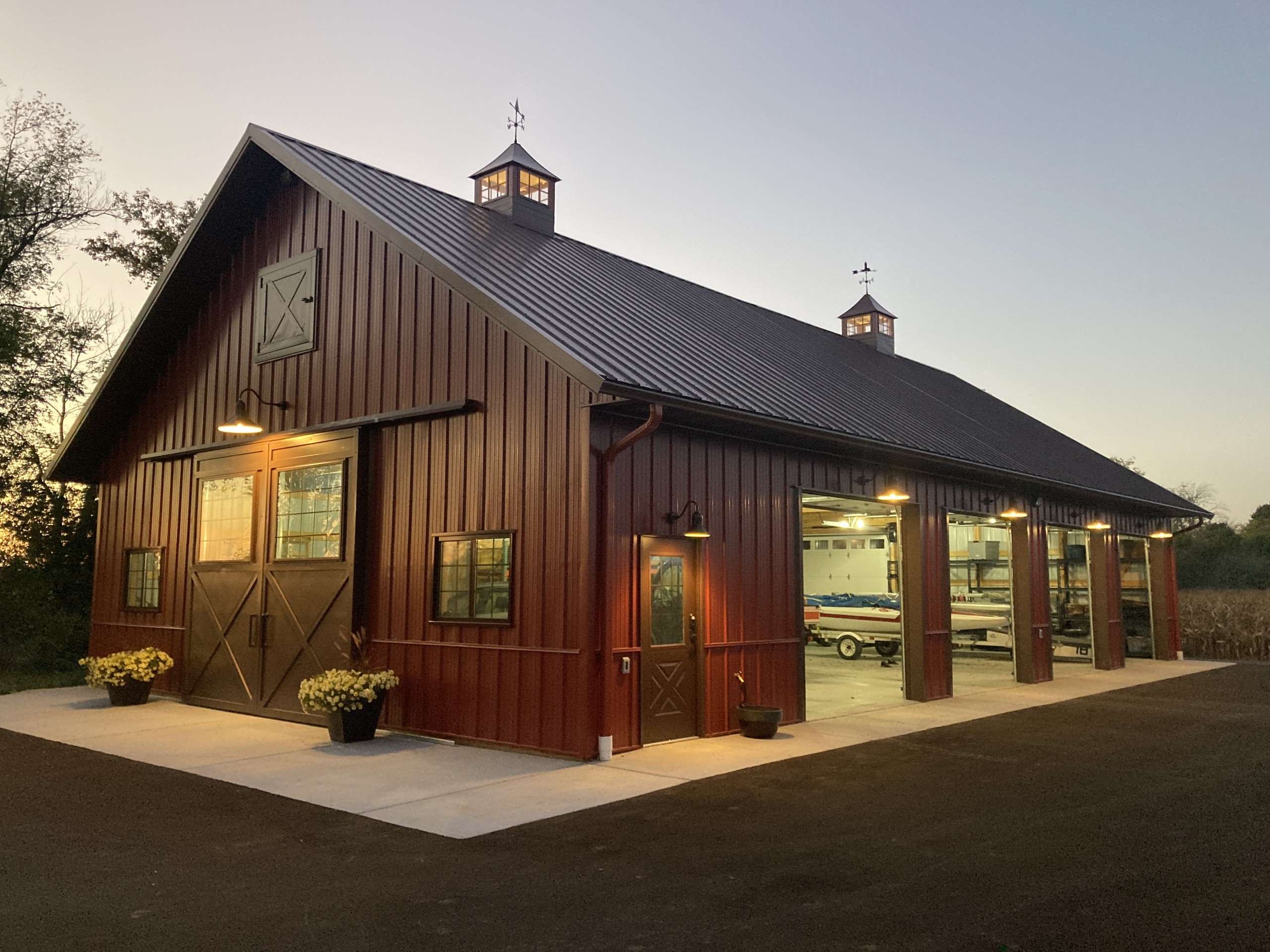 36′ × 64′ custom machinery storage building with overhead doors open at dusk