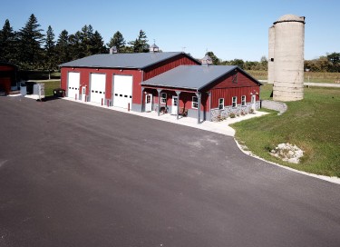 Lone Silo Storage facility with red steel building, overhead storage doors, office entrance, and silo in Waukesha Wisconsin