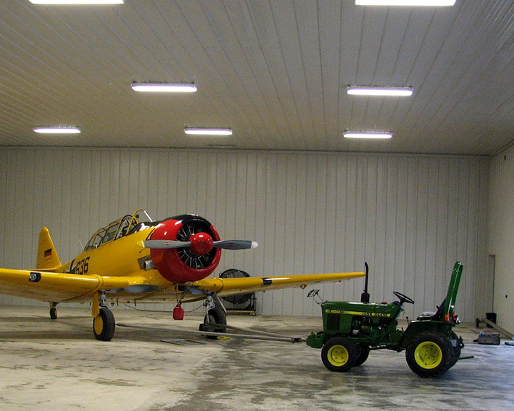 Yellow Plane and Tractor Stored Inside Post-Frame Airplane Hanger