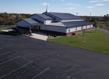 Pleasant Hill Christian Church with steel siding, large parking lot, and steeple in Kentucky Kentucky Featured Image