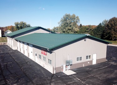 Kohlsville Fire Department building with steel siding, green roof, and multiple overhead doors in Wisconsin
