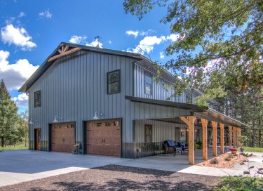 Luxury barndominium with charcoal steel siding, black trim, and modern farmhouse design in Wisconsin