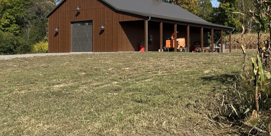 36' x 72' Board and batten pole barn with brown siding, steel roof, covered porch, and gooseneck lighting in Wisconsinside porch, twin cupolas, and Burnished Slate roof