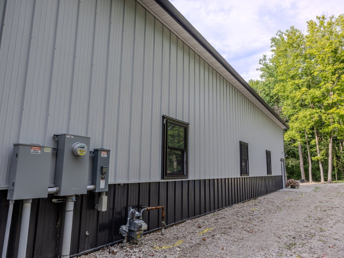 Side elevation of custom post-frame storage building with white steel siding and black trim