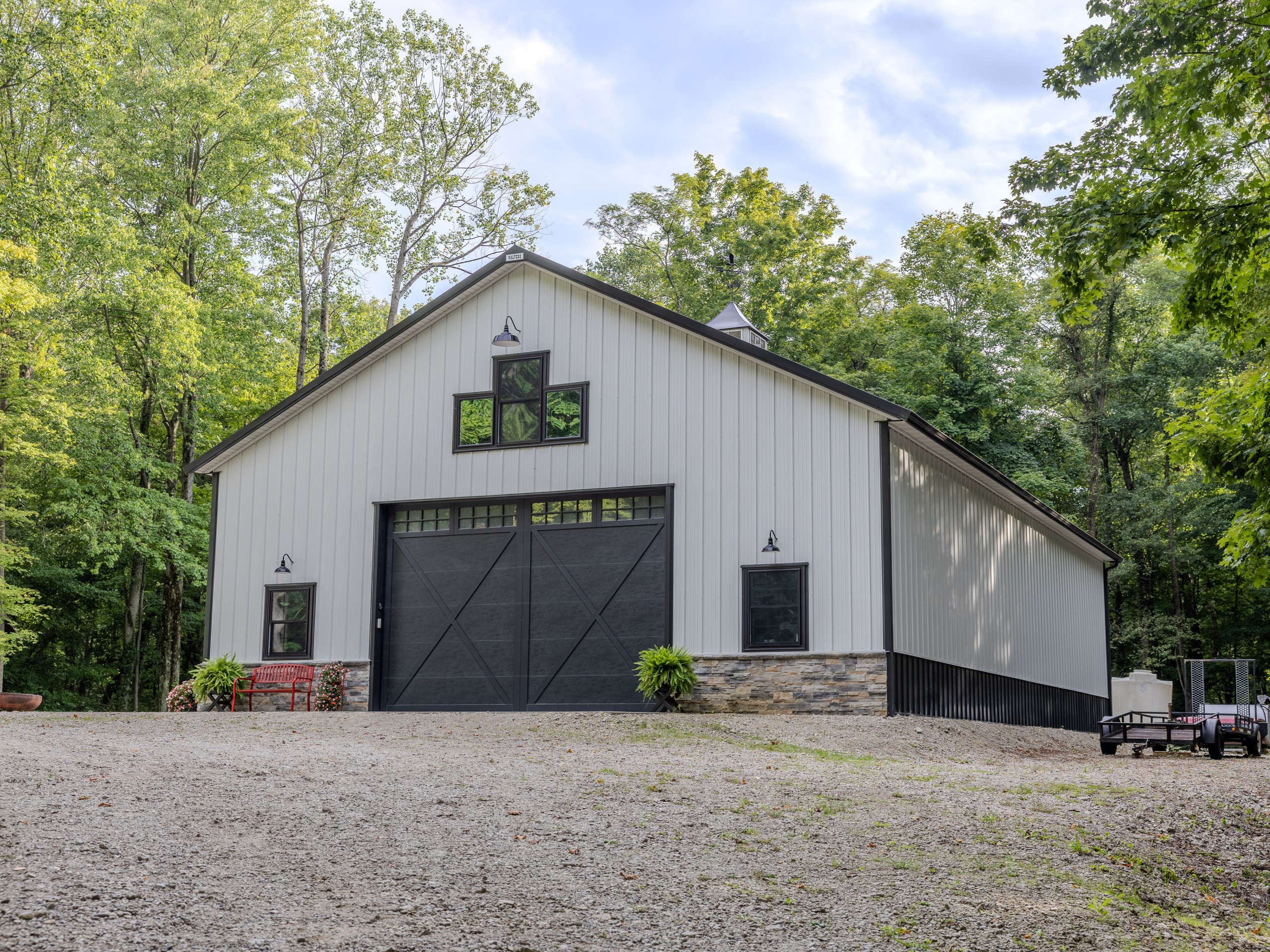 42' x 64' pole barn storage building with stone wainscot, black trim and custom overhead door