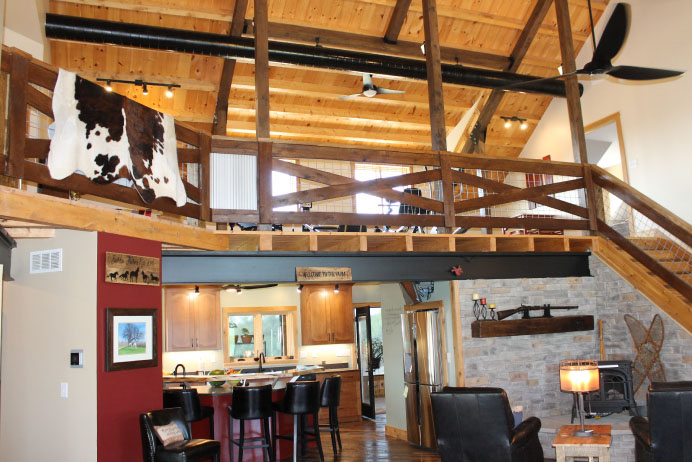 Covered wraparound porch with timber posts, wood ceiling, and outdoor seating