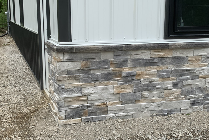 Interior of post-frame building with wood trusses, high ceiling, open overhead door, and large storage space