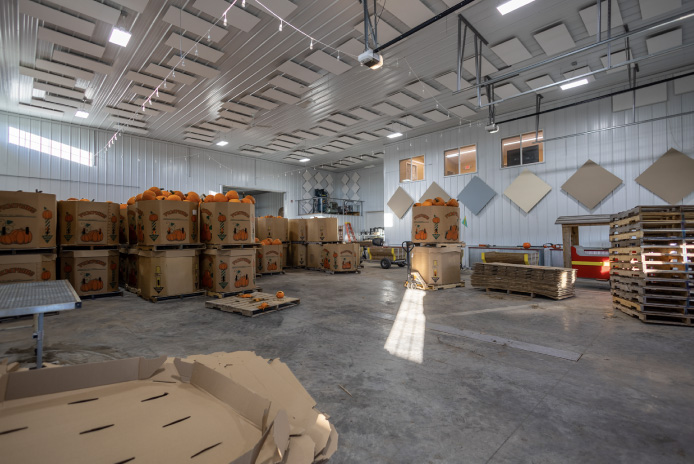 Covered porch and entry detail with cedar posts, exposed truss accents, and red metal roof creating a warm and inviting customer-facing entrance