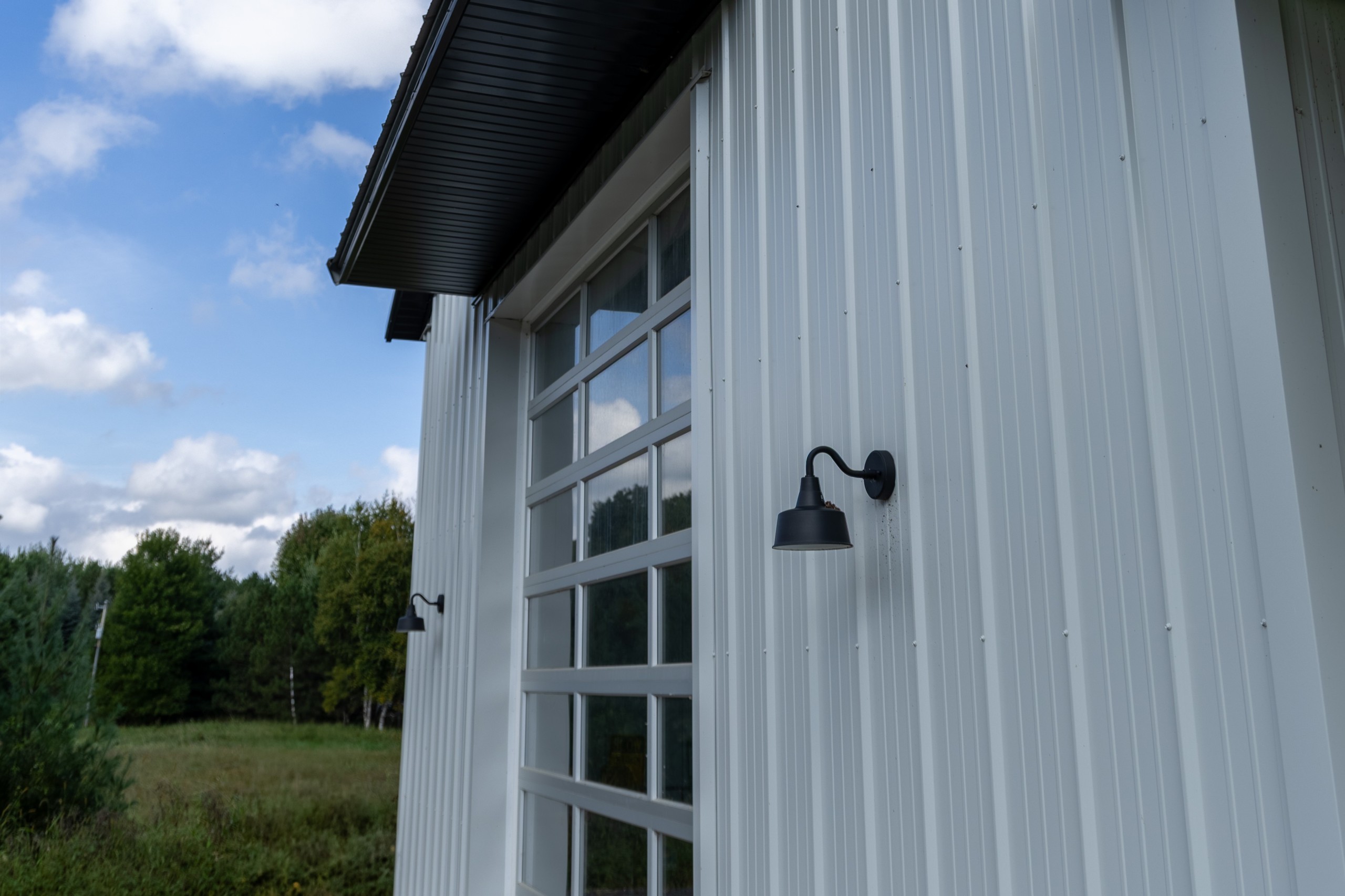 30' x 48' pole barn garage detail with C.H.I. overhead door, eyebrow overhang, and exterior gooseneck sconces