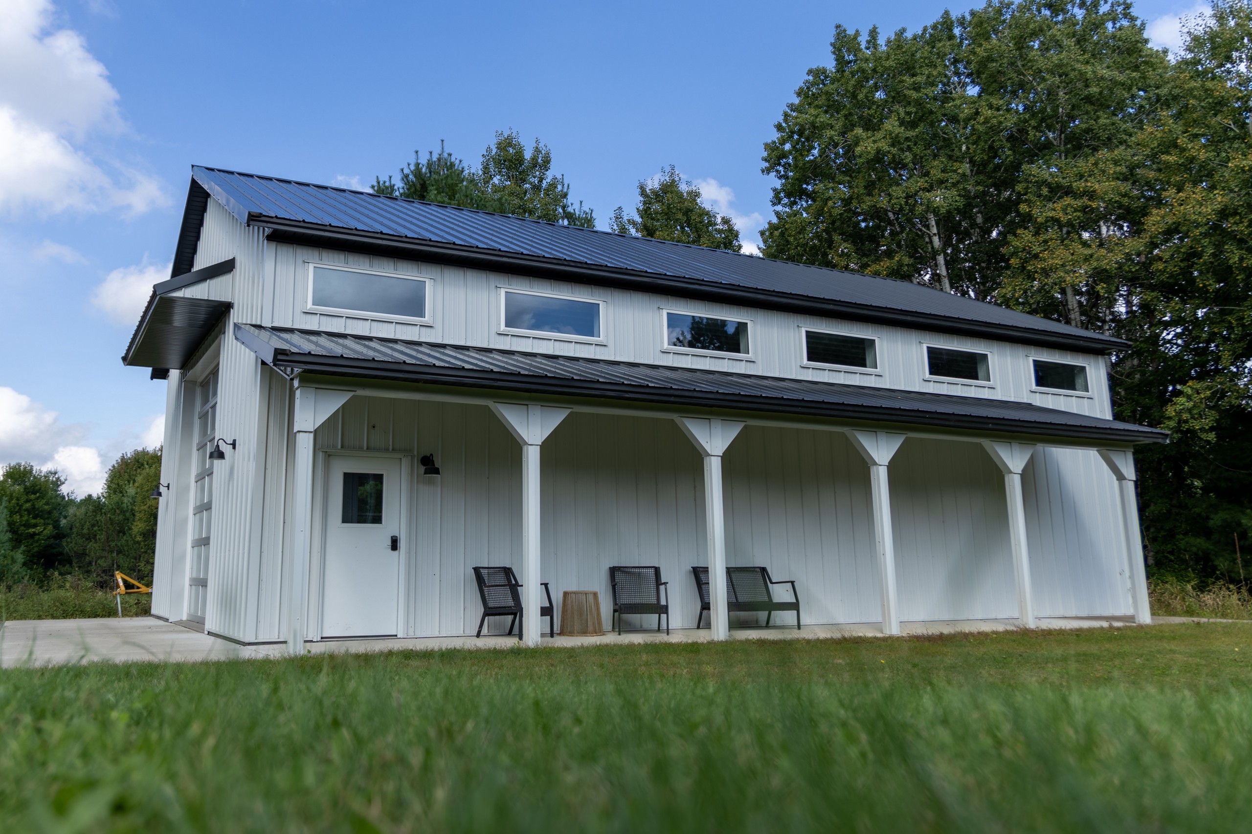 30' x 48' pole barn with 6' x 40' side porch and six upper vinyl windows for natural light