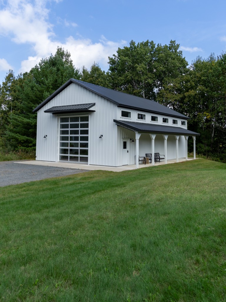 30×48 Pole Barn 30' x 48' custom pole barn garage with white steel siding, black trim, side porch, and glass C.H.I. overhead door