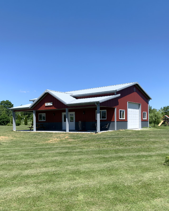 30x40 red pole barn hobby garage with covered porch white steel roof and wainscot siding