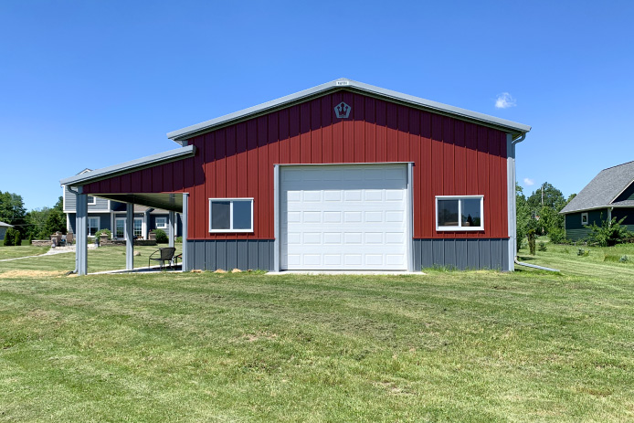 30x40 red pole barn garage with white overhead door covered porch and gray wainscot steel siding