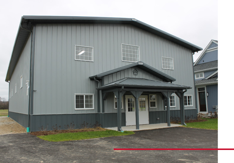 Private Indoor Basketball Court Building | Luxury Sports Barn | Walters Buildings Private indoor basketball court building with gray steel siding and custom post frame sports facility design