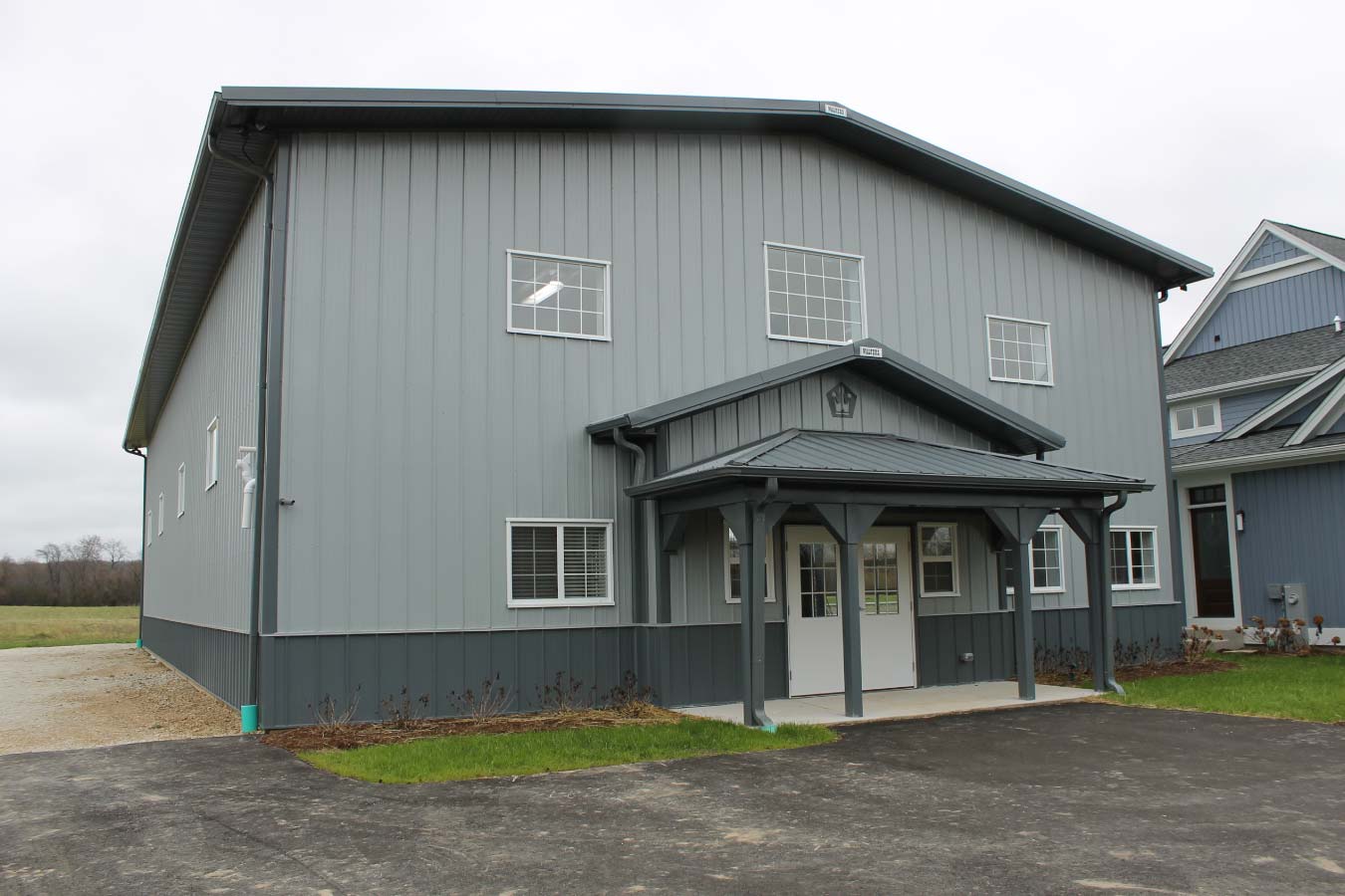 indoor basketball court building with gray steel siding and custom post frame sports facility design Title: