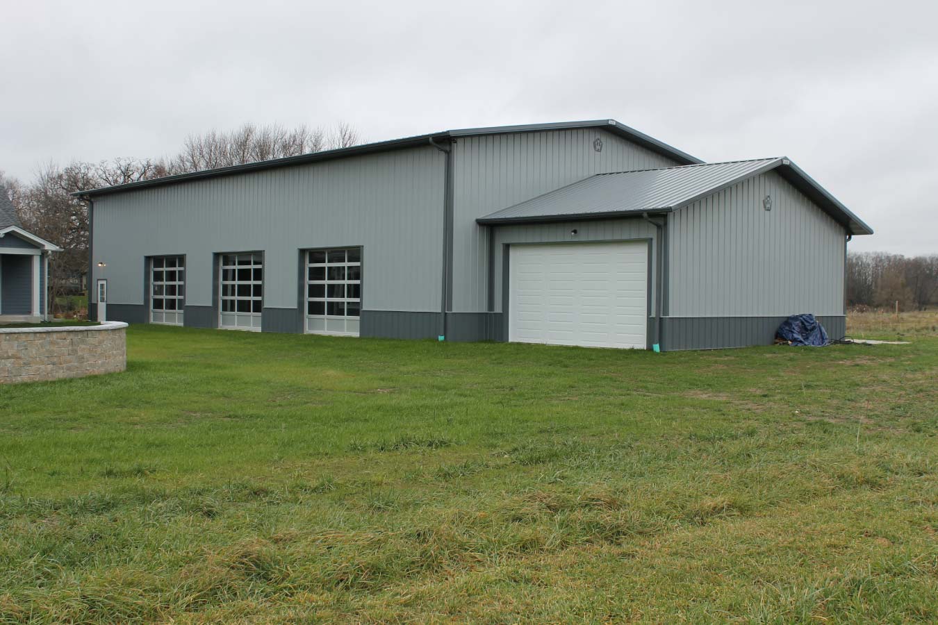 Large indoor basketball court building with gray steel siding and clear-span post frame construction
