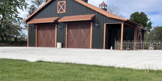 36x50 metal garage with black steel siding, copper roof, cupolas, side porch, and custom post-frame design by Walters Buildings