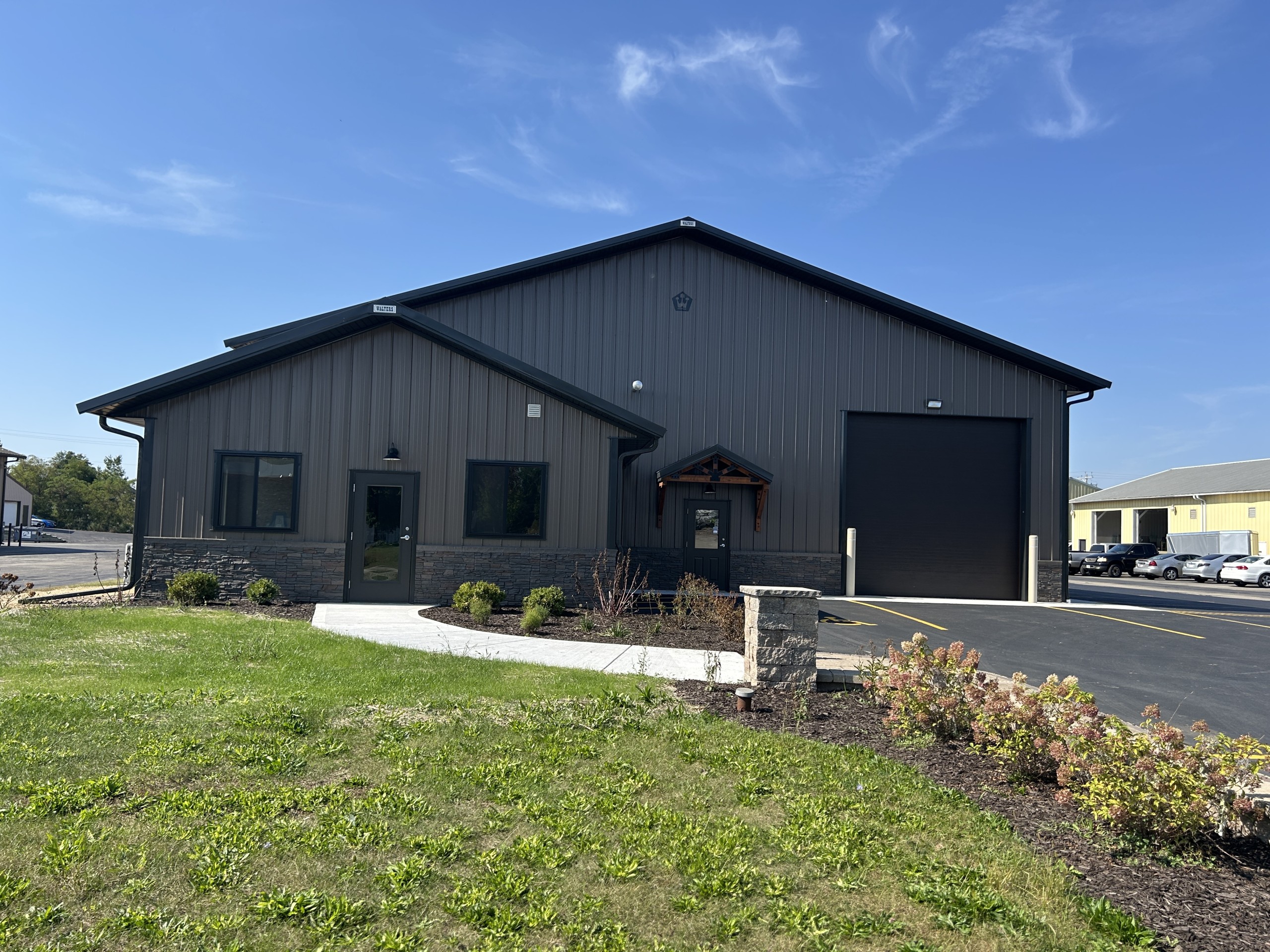 Commercial flex space office entrance with cedar gable canopy and stone wainscot