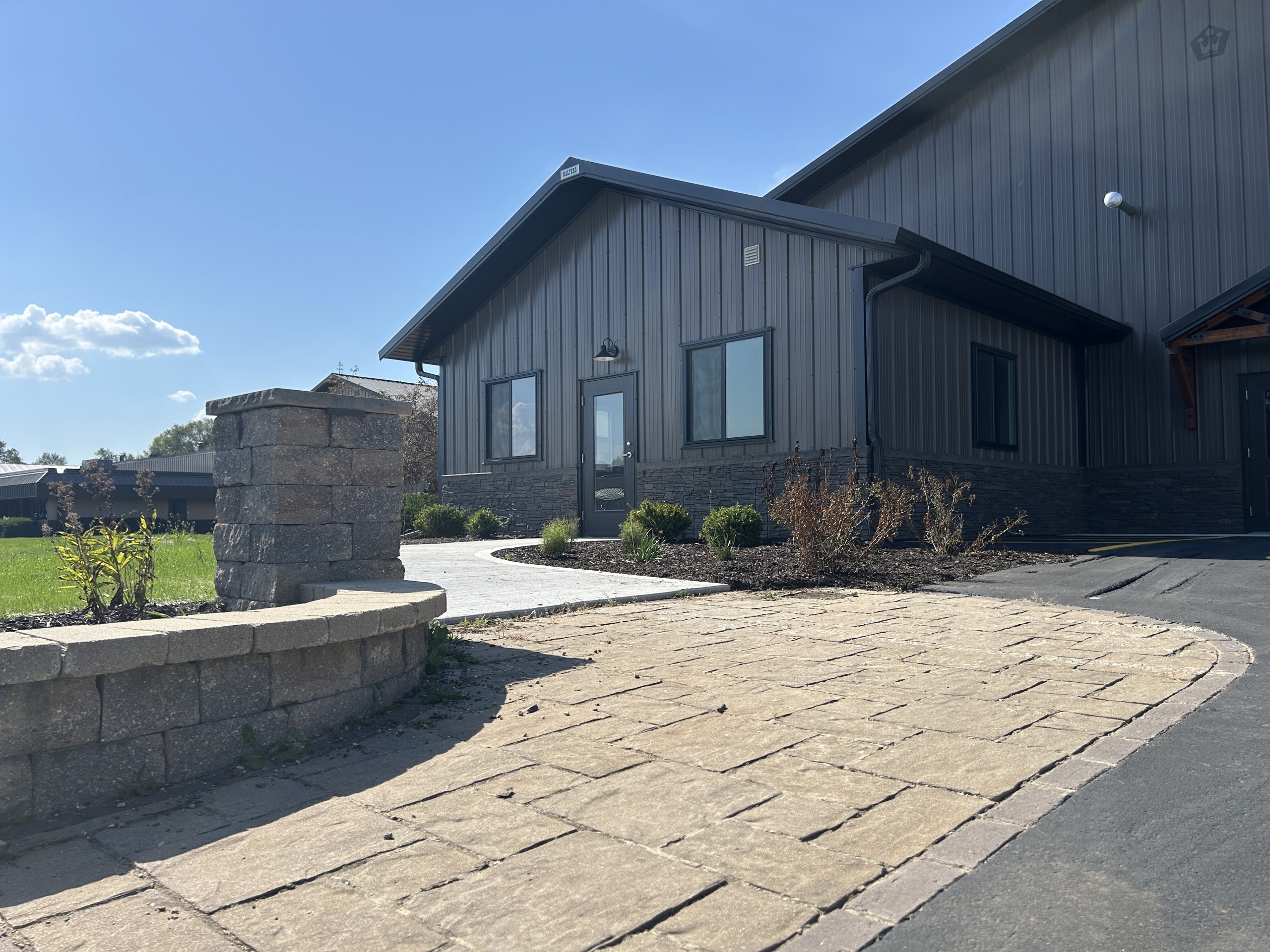 Commercial flex space office entrance with custom brick walkway and stone retaining wall
