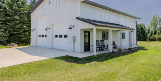 36x50 pole barn garage with covered porch, white steel siding, dark metal roof and multiple overhead doors