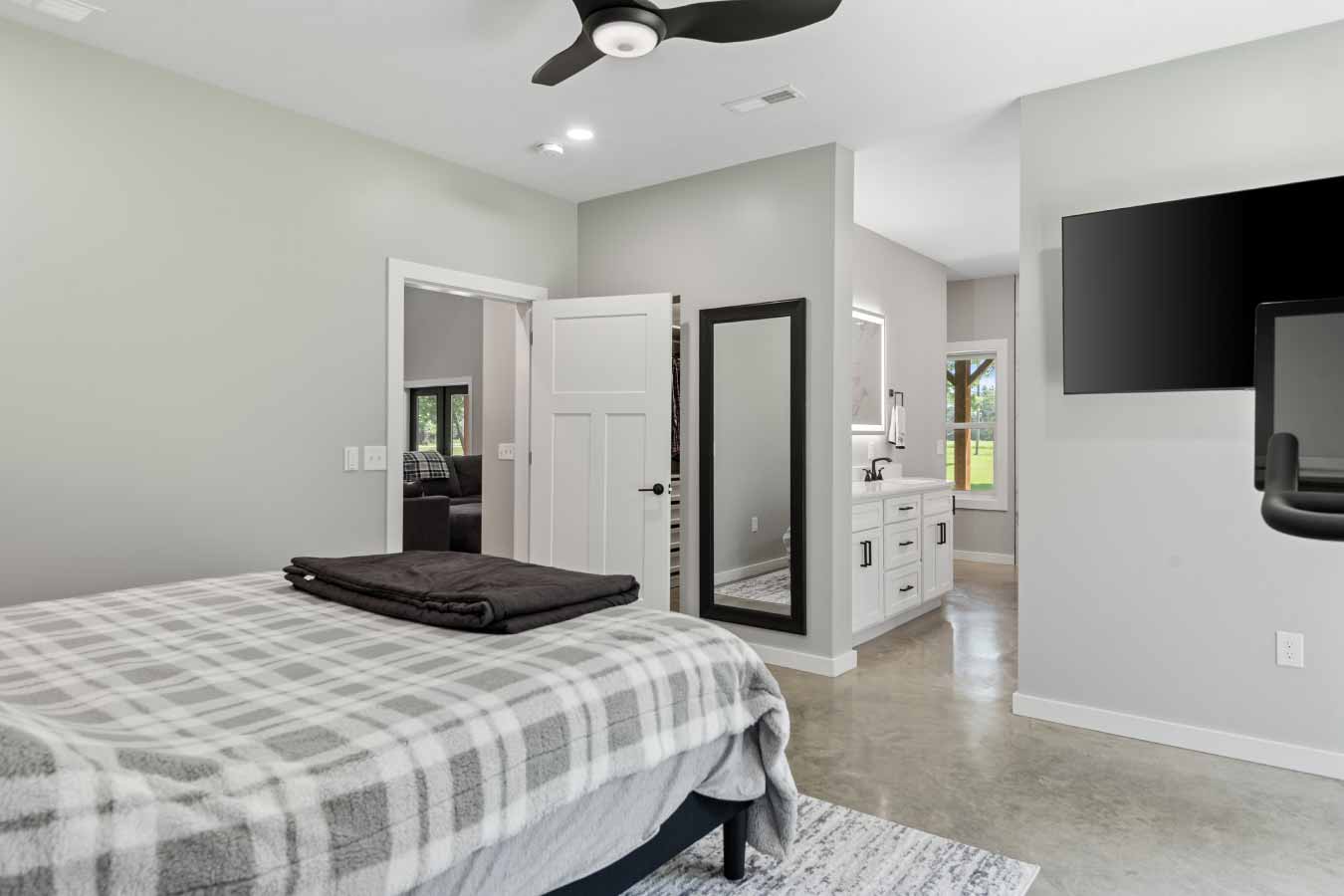 View from primary bedroom showcasing open access to walk-in closet, en suite bathroom with double vanity, and entry to main living area.