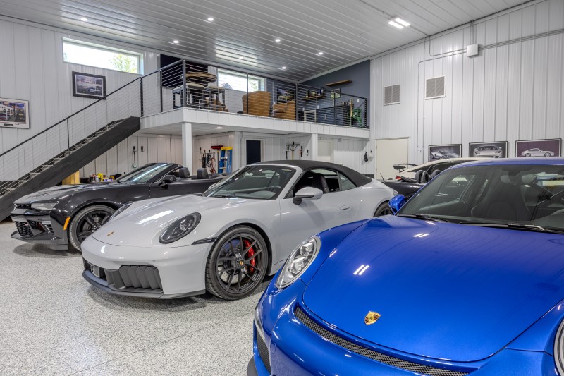Mezzanine Overlooking a Luxury Porsche Car Collection Luxury Porsche sports cars displayed beneath a second-floor mezzanine with cable railings inside a custom car collector garage in Wisconsin.