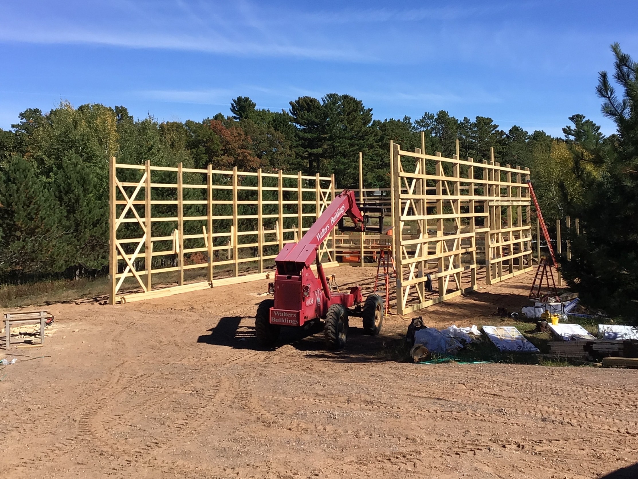 A pole barn under construction with a telehandler